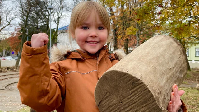 Menina segurando um troncobetesporte cnpjárvore