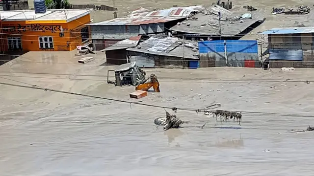 26 अगस्त, 2026 को नेपाल में अचानक आई बाढ़ के बाद क्षतिग्रस्त संपत्ति और पानी से भरी सड़कें. 