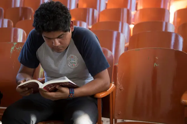 Eduardo lee un libro en un aula universitaria