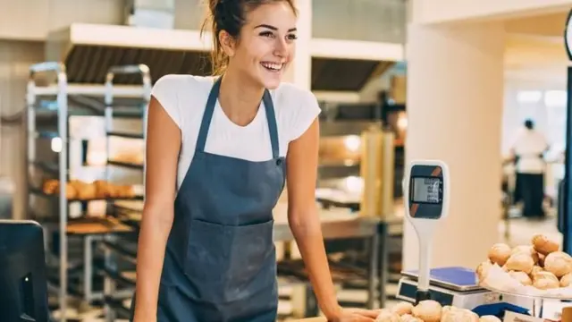 ਰਸੋਈ ਦੇ ਕਾਊਂਟਰ ਉੱਤੇ ਖੜ੍ਹੀ ਔਰਤ