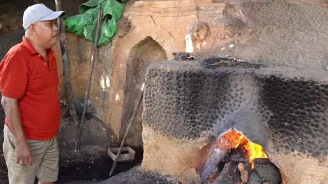 Nurhadi sử dụng hai lò đốt của mình ở làng Batu Ampar, Indonesia để sản xuất than củi