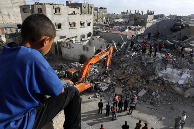 فرق الدفاع المدني والسكان المحليون يقومون بجهود البحث والإنقاذ بعد قصف إسرائيلية أصاب مبنى لعائلة عبد العال في رفح، غزة في 24 أبريل/نيسان 2024، ما دمر العديد من المباني وألحق أضراراً جسيمة بالمنطقة