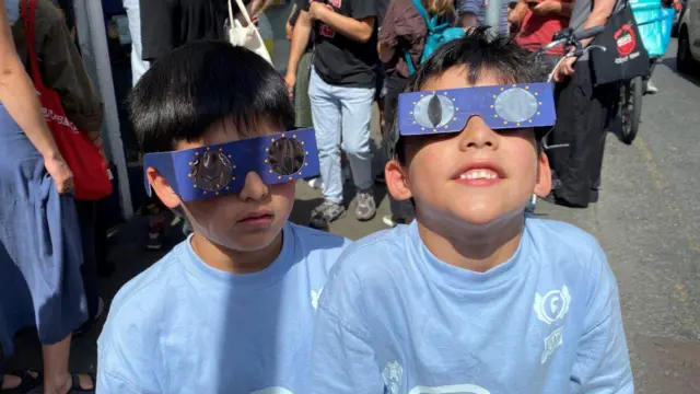 Os gêmeos Faron e Soren Walshe, de 7 anos, com seus óculos para observar o eclipse na George's Street, em Dublin, na Irlanda