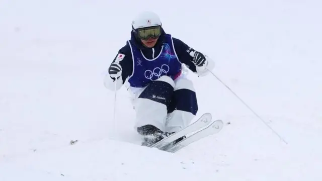 堀島がコブを滑っている。両足、両スキーをそろえ、膝をかかえるようにし、前方を見据えている