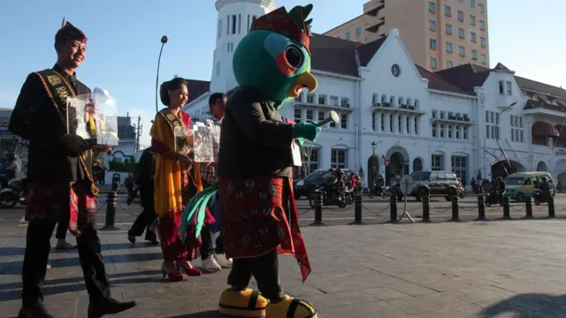 Petugas mengenakan kostum maskot Pilkada Jawa Timur 2024 Si Jali (Jatim Memilih) berkeliling saat sosialisasi di kawasan Kota Lama Surabaya, Jawa Timur, Jumat (23/8/2024). Sosialisasi yang dilakukan KPU Jawa Timur itu untuk mengajak masyarakat menggunakan hak pilihnya pada Pilkada 2024 yang digelar 27 November 2024.
