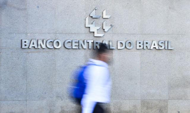 Silhuetacomo ganhar dinheiro na roleta spin payhomem passandocomo ganhar dinheiro na roleta spin payfrente ao logotipo do Banco Central do Brasil