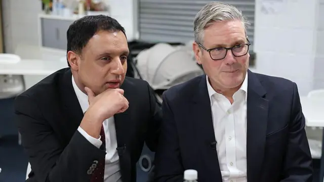 Başbakan Keir Starmer (sağda) ve İskoç İşçi Partisi lideri Anas Sarwar (solda), 4 Aralık 2025'te İskoçya'nın Glasgow kentindeki bir toplum merkezini ziyaretleri sırasında halkla konuşuyorlar. 