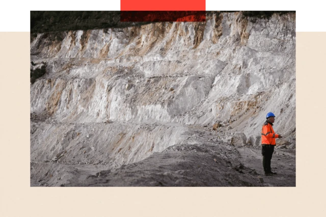 Un employé marche dans la mine à ciel ouvert d’une usine de lithium