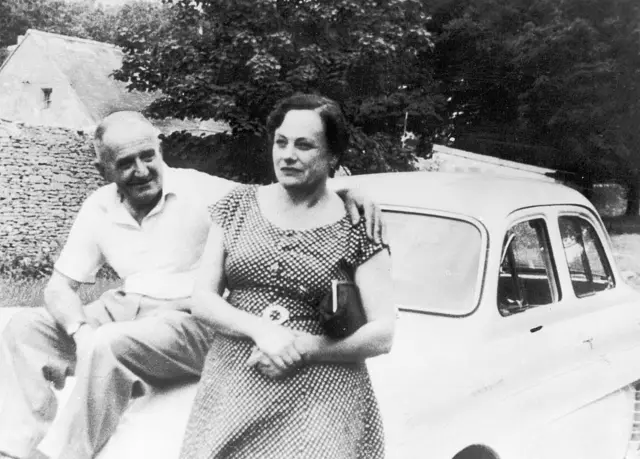 Чоловік та жінка сидять на капоті машини на чорно-білому фото