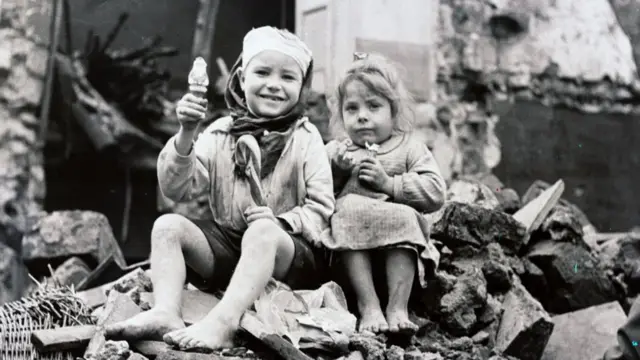Two little Italian children who sit before their mined home during the World War II