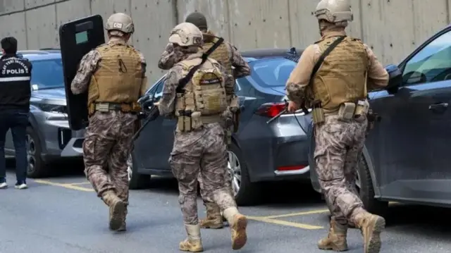 Спецпризначенці турецької поліції йдуть повз припарковані автомобілі