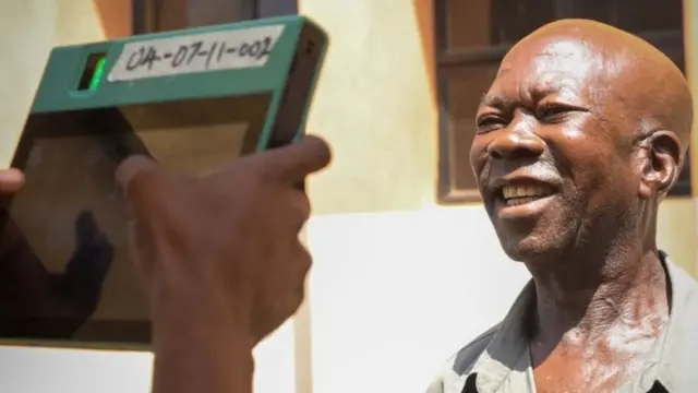 Man smile as Inec official use BVAS dey confam im facials during di govnorship election