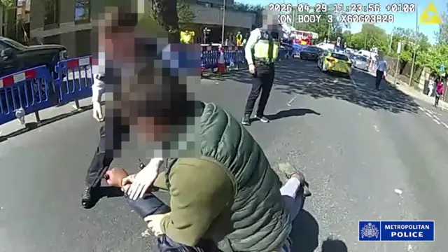 لقطة شاشة من كاميرا مثبتة على أجساد رجال الشرطة، نشرتها شرطة العاصمة، تُظهر ضباطًا يواجهون ويعتقلون رجلاً يبلغ من العمر 45 عامًا، ولا يزال رهن الاحتجاز، وذلك عقب حادثة طعن شخصين في غولدرز غرين، شمال غرب لندن.