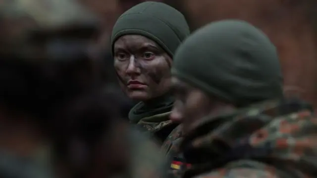 Almanya ordusuna katılan yeni kadın askerler, kamuflaj boyaları içinde görülüyor