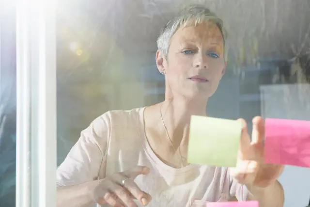 Mulher madura colando post-its