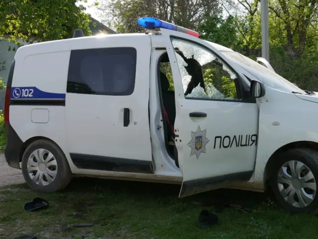 поліцейська машина з простреленими вікнами