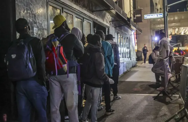 Des demandeurs d'asile font la queue devant l'hôtel historique Roosevelt, transformé en centre d'accueil pour les familles de migrants nouvellement arrivées à New York, États-Unis.