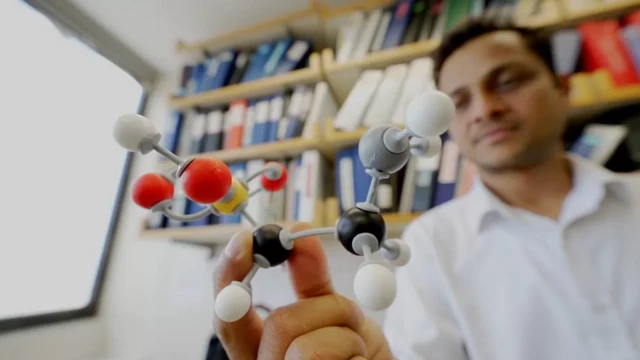 ดร. วิชัย ยาทพ ถือแบบจำลองโครงสร้างโมเลกุลของทอรีน