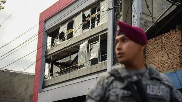 Miembro de la fuerza pública colombiana frente a un edificio afectado por ataques en Cali en agosto de 2025.