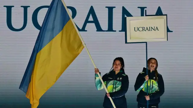 Прапор України, який несуть дві волонтерки 