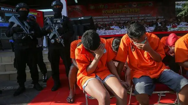 Sejumlah tersangka menutupi wajahnya saat gelar perkara tindak pidana pencucian uang (TPPU) lintas negara di Lapangan Bhayangkara, Mabes Polri, Jakarta, Selasa (12/9/2023).