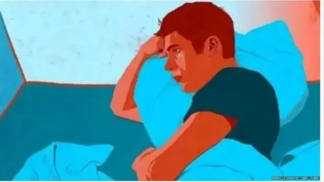 Ọkunrin kan dubulẹ sori ibusun, o fọwọ kan sabẹ ori rẹ to gbe irọri si