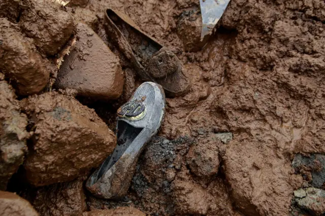 Sepasang sepatu tergeletak di lokasi yang terdampak banjir bandang di Kelurahan Rua, Kota Ternate, Maluku Utara, Minggu (25/8/2024). Banjir bandang yang membawa material tanah, pasir dan batu dari Gunung tersebut menerjang kelurahan Rua akibat hujan deras pada pukul 04.00 WIT Minggu dini hari dan tiga orang ditemukan meninggal dunia, sementara tim gabungan masih melakukan proses pencarian korban yang tertimbun lumpur banjir bandang. ANTARA FOTO/Andri Saputra.