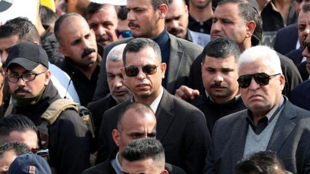 نفر اول از سمت راست، فالح فیاض، رئیس حشد شعبی در مراسم تشییع قاسم سلیمانی و ابومهدی مهندس معاون حشد شعبی در بغداد