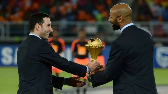 المهاجم المالي فريدريك كانوتي (إلى اليمين) ولاعب الوسط المصري محمد أبو تريكة يسلمان كأس كأس الأمم الأفريقية 2015 