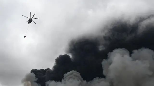 Пожежний гелікоптер над клубами диму