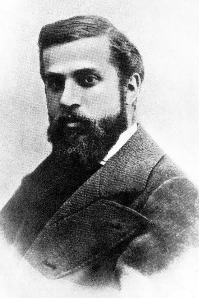 Retrato em preto e branco do arquiteto espanhol Antoni Gaudí, um homem de barba, usando sobretudo