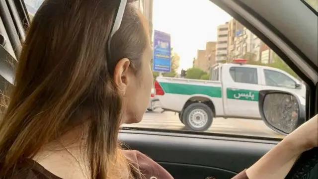 زن بی حجاب کنار خودروی پلیس