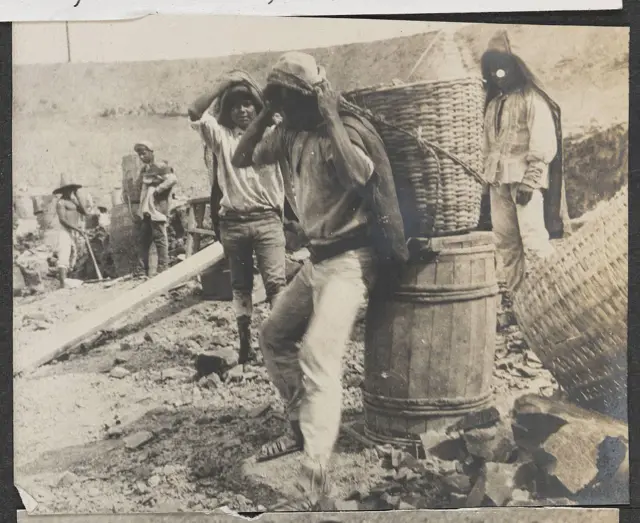 Jóvenes cargando canastos y barriles