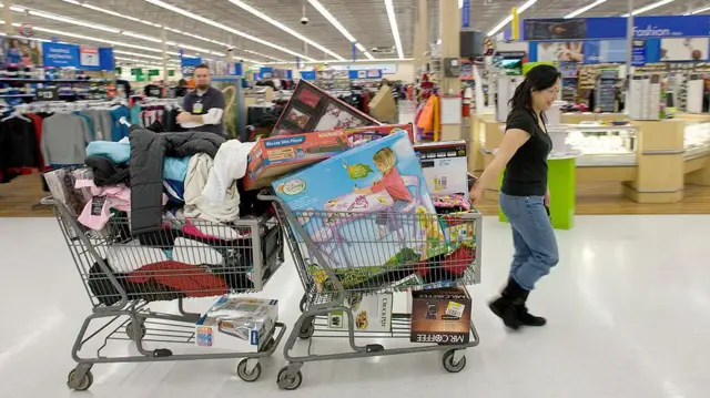 A US shopper dragging two trolleys full of products during the 2009 Black Friday sales