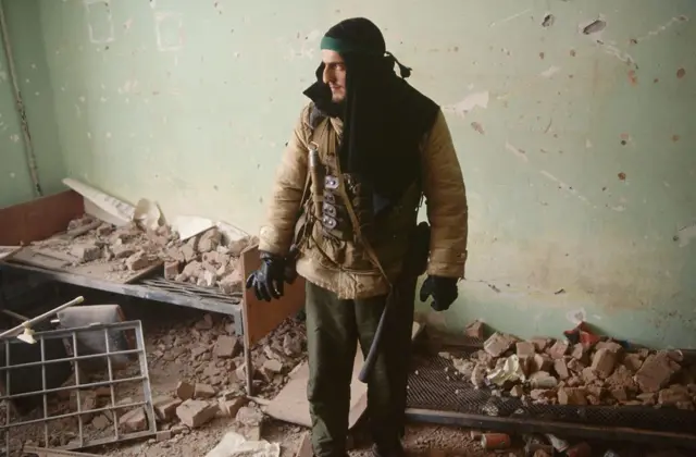 Чеченский боец в разрушенном доме в центре Грозного 