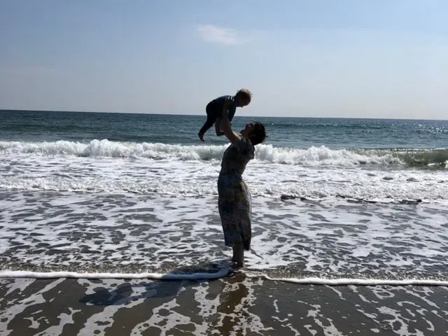 Laura en una playa con su hijo