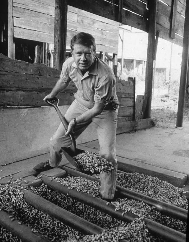 A younger Jimmy Carter shovelling peanuts 