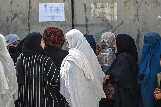 شماری از زنان بازنشسته که پشت اداره تقاعد تجمع کرده‌اند.