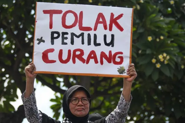 Pengunjuk rasa yang tergabung dalam Aksi Rakyat Semesta membawa poster saat menyampaikan aspirasinya di depan kompleks Parlemen, tepi Jalan S. Parman, Senayan, Jakarta, Jumat (1/3/2024). 