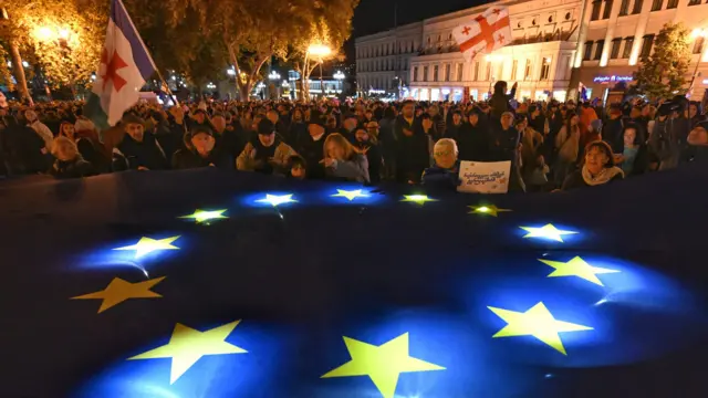 An image of protesters lighting a giant European Union flag during a pro-Europe rally ahead of the parliamentary elections in Georgia. 