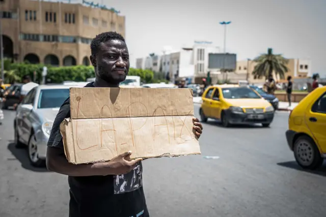 Wani mutum rike da kwali a kan titi