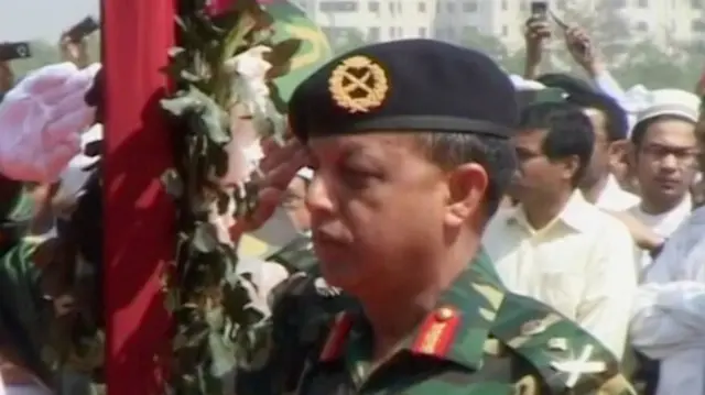 সেনাসদস্যদের মরদেহের সামনে শ্রদ্ধা জানানোর সময় তৎকালীন সেনাপ্রধান জেনারেল মইন ইউ আহমেদের ছবি