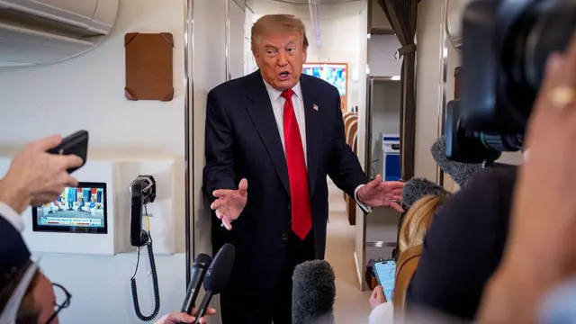 ABD Başkanı Donald Trump, 27 Temmuz 2026'da Michigan'a yaptığı yolculuk sırasında Air Force One uçağında gazetecilere konuşuyor. Andrew Harnik/Getty Images)