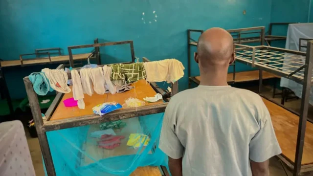 One man wey dem abduct im pikin dey look inside di students dormitory. You fit see some of di students clothes dia wey dem leave run.