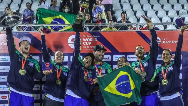 Mulheres e homens levantando troféus e mostrando medalhas