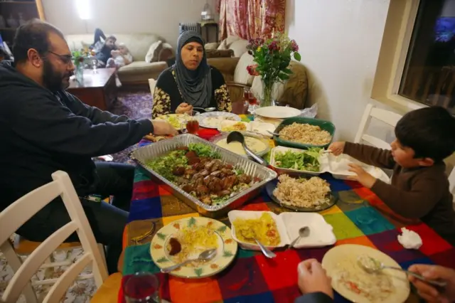 La famille Alhamdan déguste des plats à emporter de chez Falafel King chez elle, à West Seattle, (février 2017). 