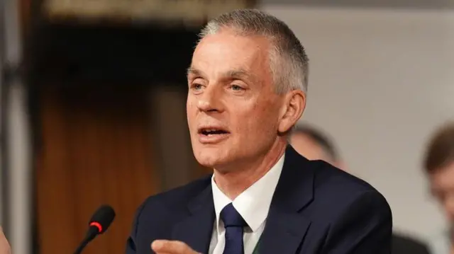 Tim Davie falando em um microfone