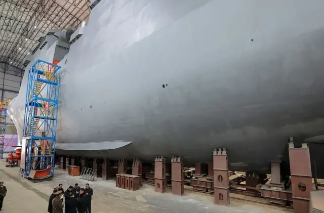 건조 중인 거대 잠수함 아래 사람들과 이야기를 나누는 김정은