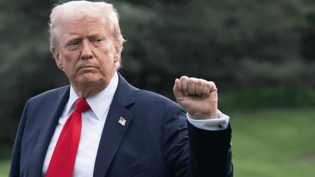 Trump Beyaz Saray'da Air Force One uçağına binerken bir yumruğunu kaldırmış halde poz veriyor
