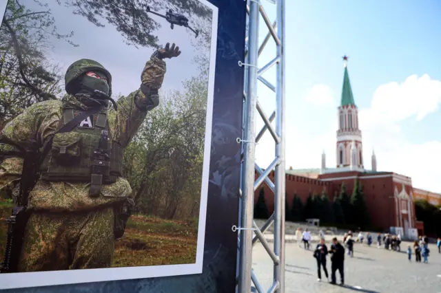 Ludzie przechodzą obok wystawy wspierającej rosyjską armię na Placu Czerwonym przy Kremlu w Moskwie, Rosja, 27 sierpnia 2025 r.